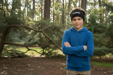 Child wearing a blue hoodie and black headband with 'empire' logo in a forest setting